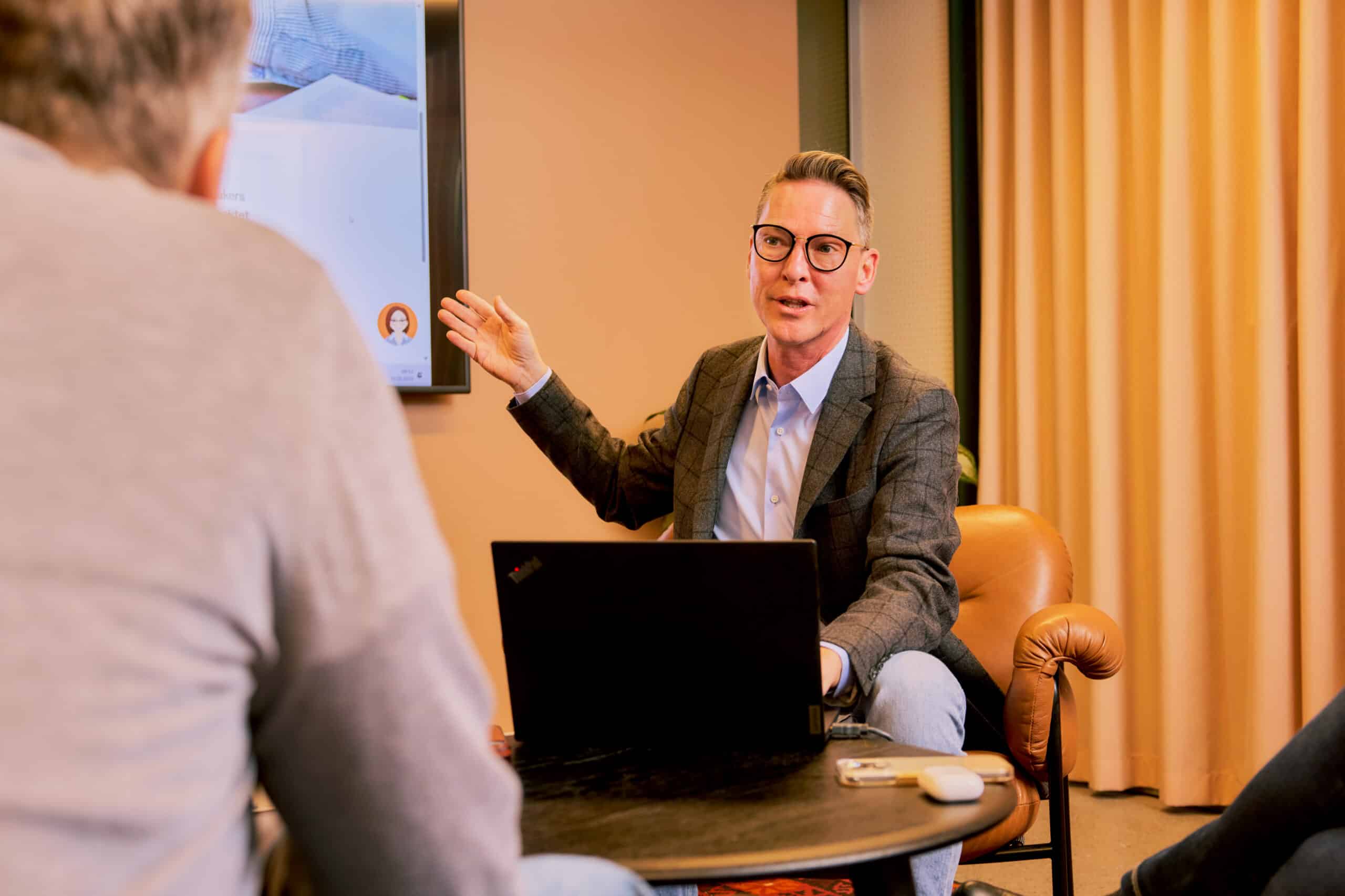 Mann som holder prestasjon og viser noe på PC/ skjerm. Foto: Shawn Arvind